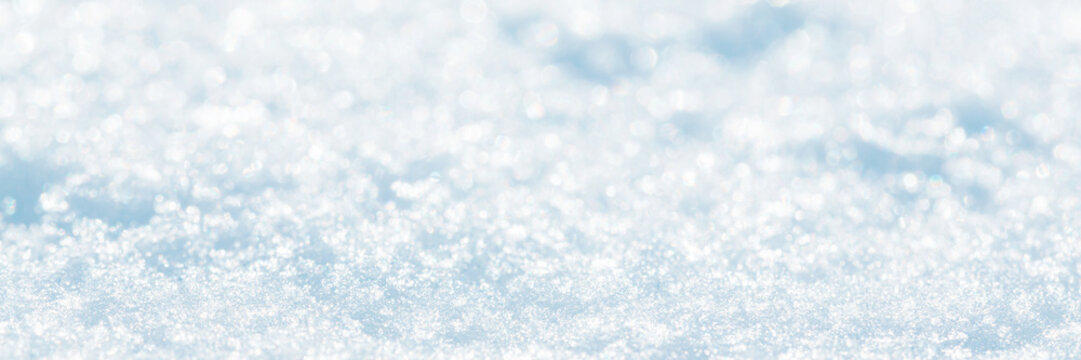 Snow surface close-up. Winter background with snow texture and beautiful bokeh. Shallow depth of field and blur. Perfect for Christmas and New Year design. View with copy space.