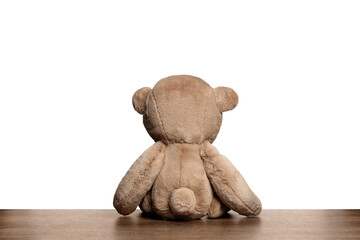 Cute teddy bear on wooden table against white background, back view