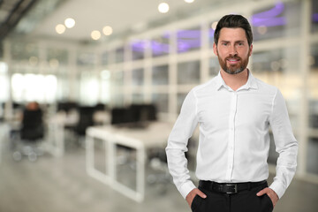 Portrait of handsome confident man in office, space for text