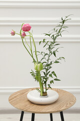 Ikebana art. Beautiful pink flowers and green branch carrying cozy atmosphere at home