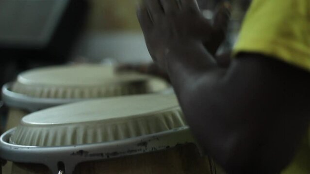 detail of hands playing timbal percussion instrument