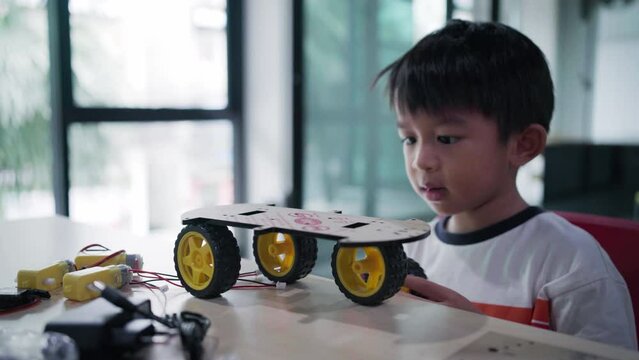 Asian  Student Boy Building Robot Vehicle In After School Computer Coding Class technology of robotics programing and STEM education concept.