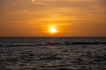 Ocean sunset. Big white sun on dramatic bright sky background, soft evening horizont over sea dark water