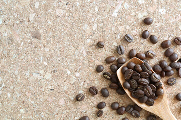 Fototapeta na wymiar Roasted coffee bean with wooden spoon on cork board. Top down, flat lay