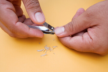 cut the fingernails part of the thumb nails. The concept of nail hygiene photos for Muslims is the sunnah of cutting nails on Monday, Thursday, Friday. isolated on yellow background