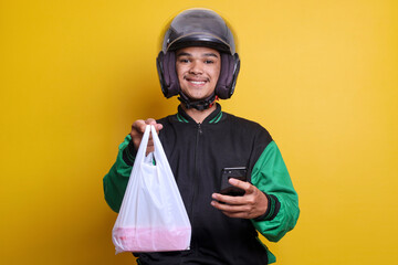 Asian online taxi driver wearing green jacket holding food wrapped in plastic while holding phone