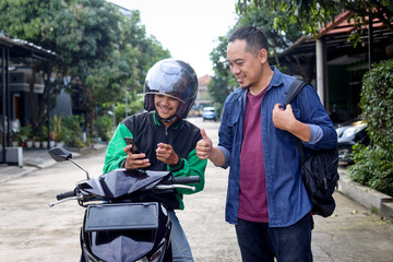 Adult man ordering a commercial motorcycle taxi driver by smartphone
