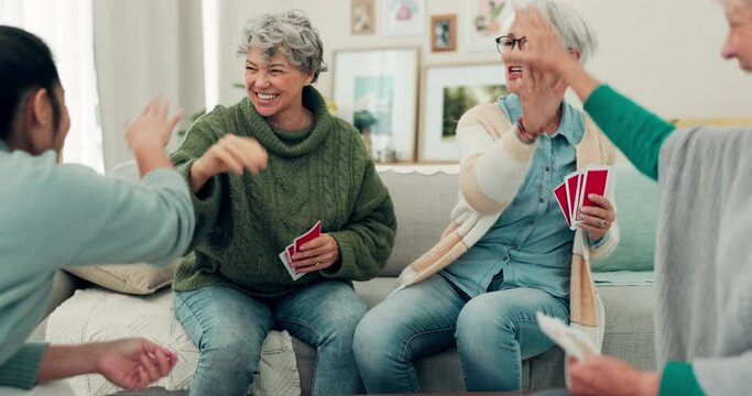 Elderly group, high five and playing card game for winning, victory or fun social entertainment together at home. Happy senior people enjoying gathering, team activity or games in the living room