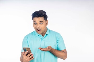 Indian man giving shocking expression after looking in smartphone.