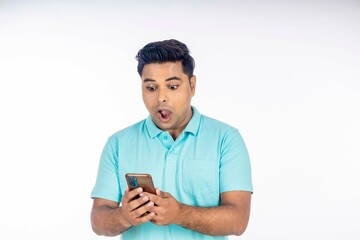 Indian man giving shocking expression after looking in smartphone.
