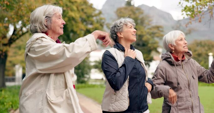 Senior friends, talking and walking together on an outdoor path to relax in nature with elderly women in retirement. Happy, people pointing and conversation in the park or woods in autumn or winter