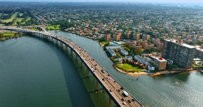 The Throgs Neck Bridge leading to the Bay Terrace in Queens, New York. Lively traffic on the bridge and beautiful cityscape from top view.