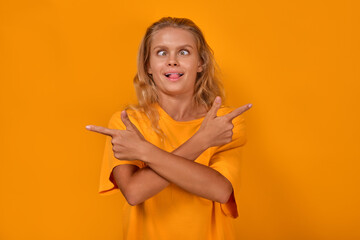 Young funny stupid Caucasian woman makes bizarre grimace and points fingers in different directions...