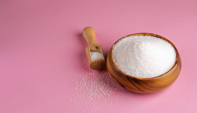 Natural sweetener in a wooden bowl on a pink background. Sugar substitute. Erythritol.