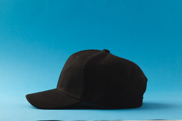 Black baseball cap and copy space on blue background