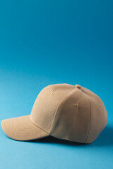 Cream baseball cap and copy space on blue background