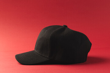 Black baseball cap and copy space on red background