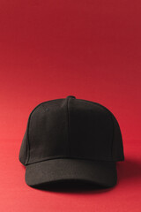 Black baseball cap and copy space on red background