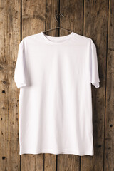 White t shirt on hanger and copy space on wooden background