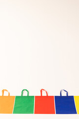 Row of multi colour canvas bags with copy space on white background
