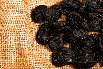 a lot of black prunes on burlap, dried plum
