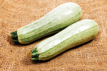 two green zucchini on burlap