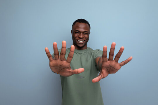 young handsome african man dressed in t-shirt shows denial and disagreement with hands