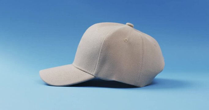 Video of beige baseball cap and copy space on blue background