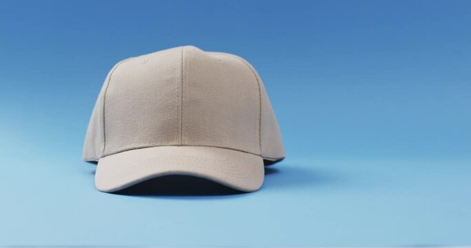 Video of beige baseball cap and copy space on blue background