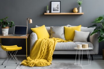 A laptop is placed on a gray sofa which is adorned with yellow pillows and a wool blanket. This cozy set up serves as the home workspace office for a blogger freelancer. The interior design of this