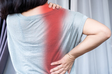 woman suffering from neck and shoulder blade pain spreading to lower back because of muscle strain