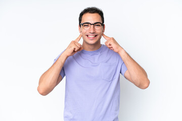 Young caucasian man isolated on white background smiling with a happy and pleasant expression