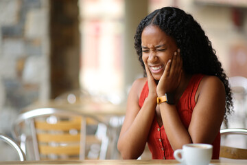 Black woman suffering tmj in a restaurant