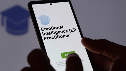 05th August 2023. A student holds a phone, enrolls in courses to study emotional intelligence (ei) practitioner program, learn new skill and pass certification. Text in English, English text.