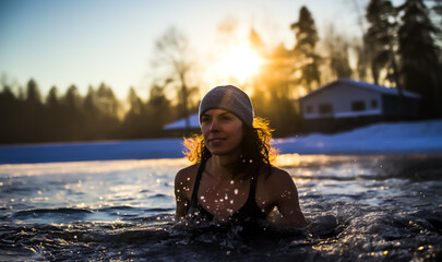 Young woman swimming in a cold frozen lake or river in winter. Concept of cold water swimming. Shallow field of view.