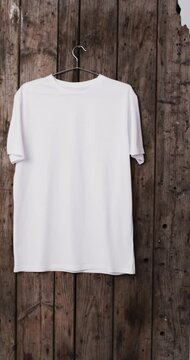 Vertical video of white t shirt and copy space on wooden background