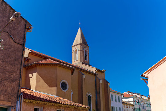 Beautiful view of village of Giens with clock tower of catholic church and historic traditional houses on a sunny late spring day. Photo taken June 8th, 2023, Giens, Hyères, France.