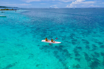 Mauritius vacation, couple man and woman in a kayak in a blue ocean in Mauritius. men and women peddling in a turqouse colored ocean of the Island of Mauritius