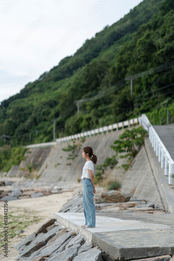 Wall mural 夕暮れの海にいる女性