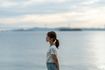 夕暮れの海にいる女性