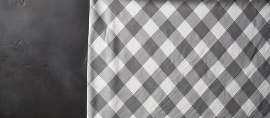 A tablecloth is folded and placed over a stone table, creating a checkered pattern. The top view