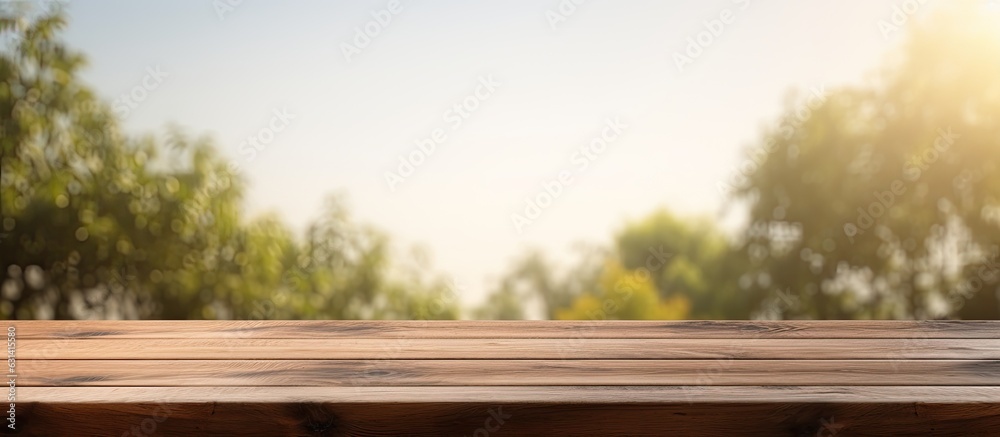 Poster a wooden table with a blank surface is placed against a blurry natural background. this space can