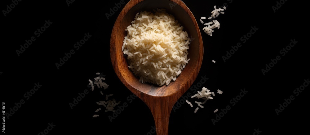 Poster uncooked surti kolam rice with a wooden spoon on a black background. there is empty space for text