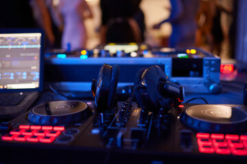 Fototapeta na wymiar DJ console cd mp4 deejay mixing desk Ibiza house techno dance music wedding reception party in nightclub with colored lighting effect disco lights.