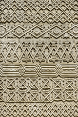 Carved embossed patterns on the  stone wall of an ancient church building as a background. Fragment, detail. Architectural features. Close-up. Selective focus.