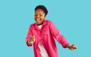Happy satisfied African American woman dancing feeling euphoric and celebrating her success. Joyful...