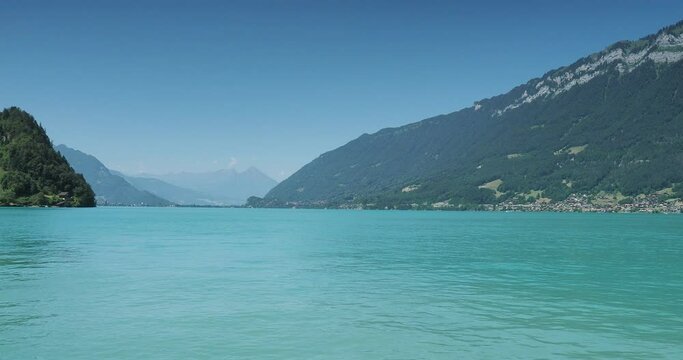 View over the calm waters of Lake Brienz from Iseltwald towards Interlaken on the horizon, Bonigen on the left bank, the villages Niederried and Ringgenberg at the foot of the Emmental Alps
