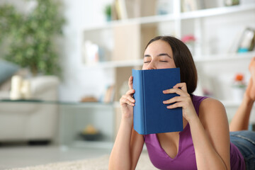 Reader smelling paper book at home