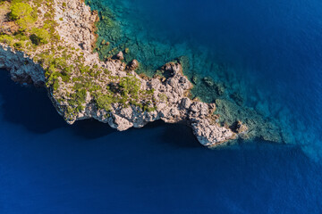 Rocky cliff aerial view. Azure sea or ocean coast. Summer resort and vacation destination