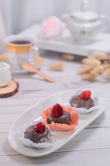 Chocolate mochi balls, Japanese dessert chocolate mochi or glutinous rice ball with strawberry topped. served on white plate, cup of tea.